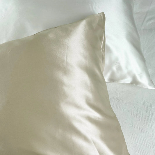 Close-up of a beige champagne pillow on a white bed