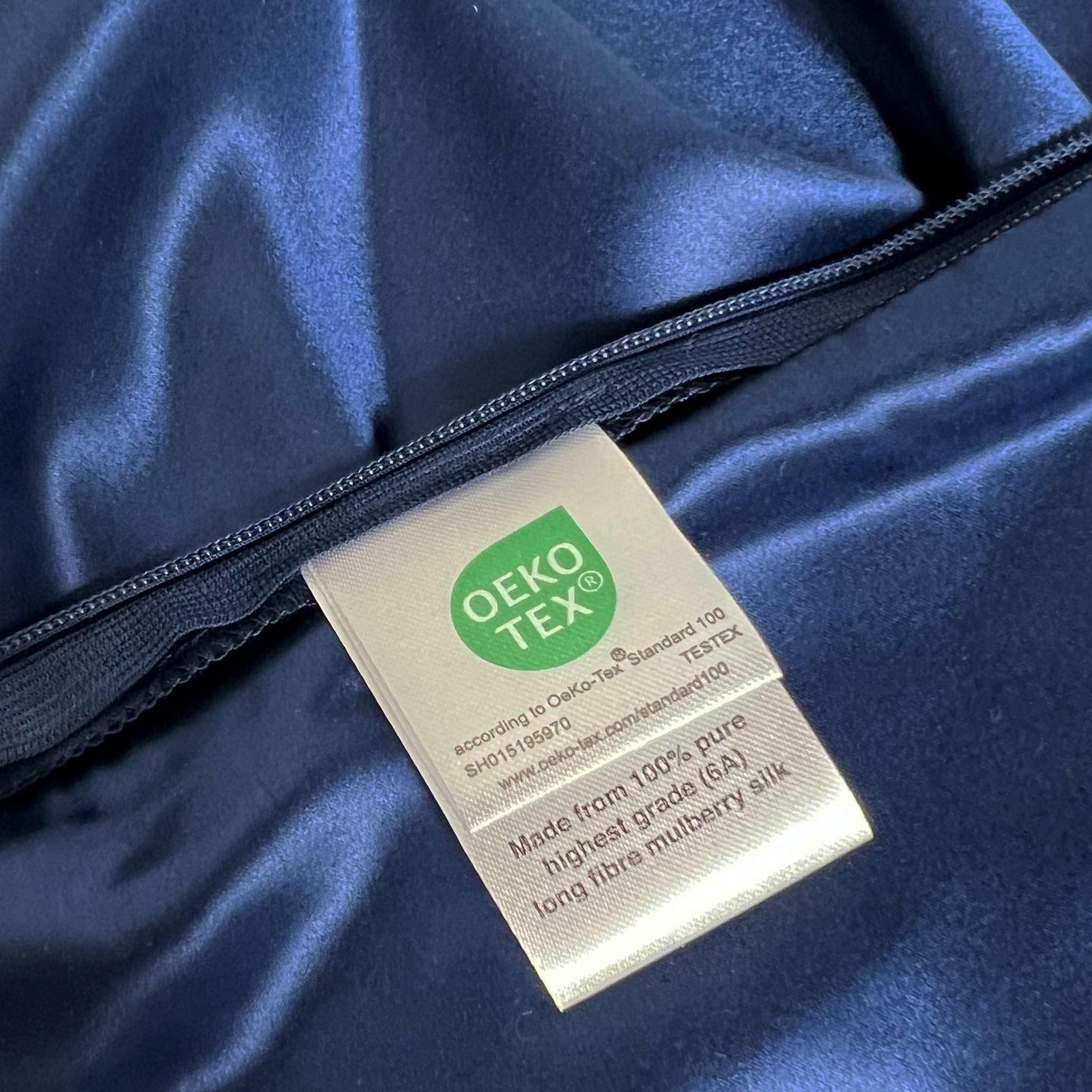 OEKO-TEX label on a navy blue 100% mulberry silk pillow case