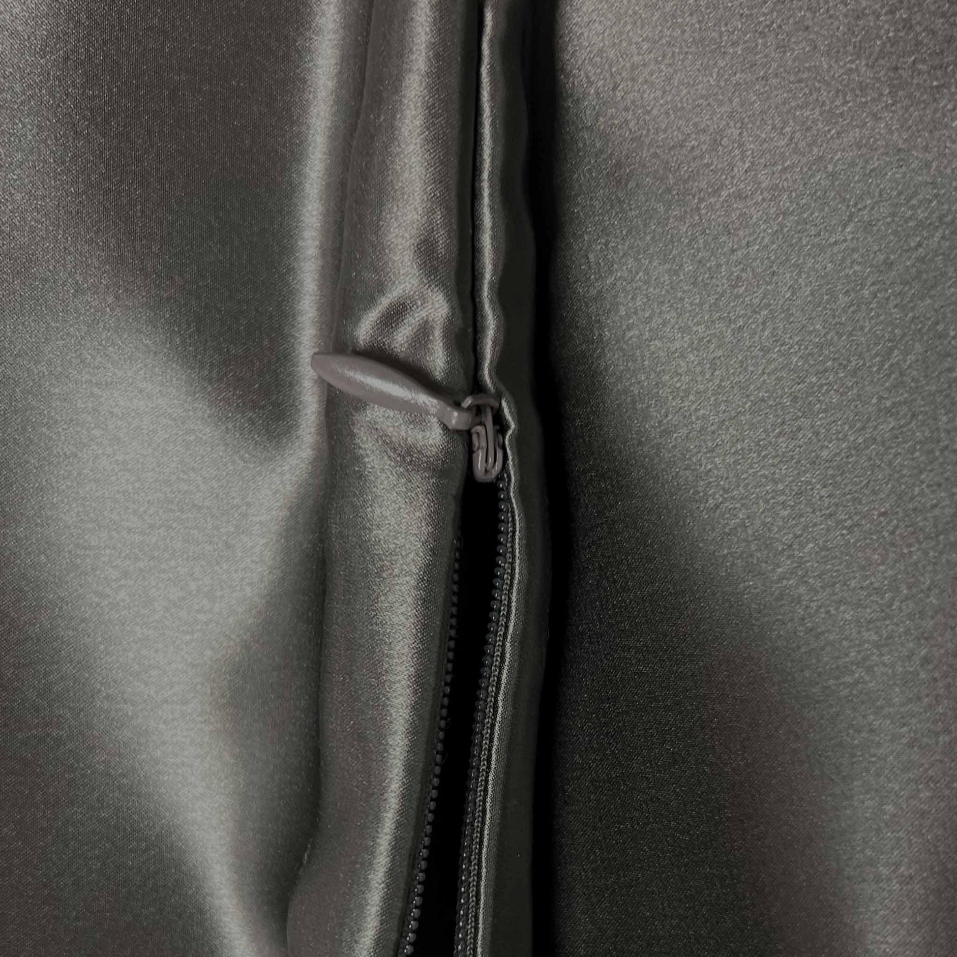 Close-up of a zipper on a gray silky fabric surface