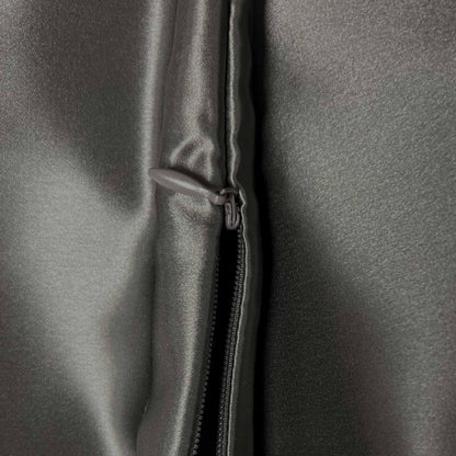 Close-up of a zipper on a gray silky fabric surface