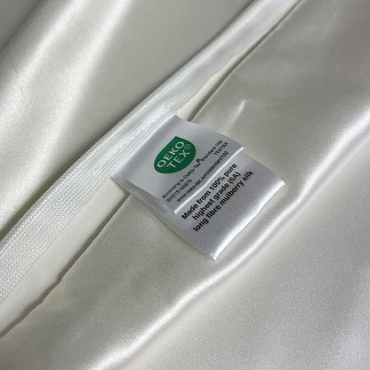 Silky white pillow case with a label featuring the OEKO-TEX logo